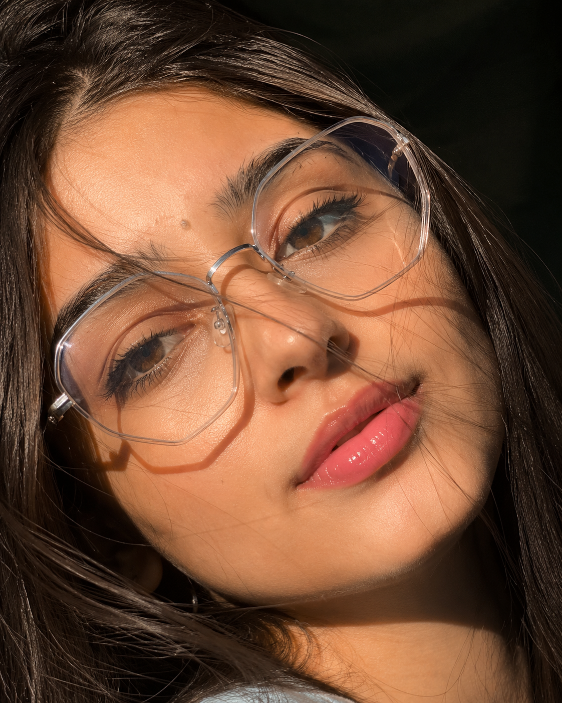 Identity-locked Harsh Sunlight Glasses Portrait AI photo editing prompt result with transparent glasses and windblown hair in harsh sunlight